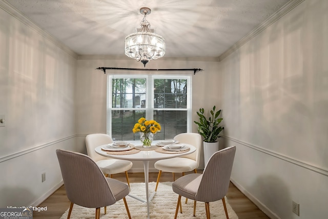 dining area featuring an inviting chandelier, hardwood / wood-style floors, and ornamental molding