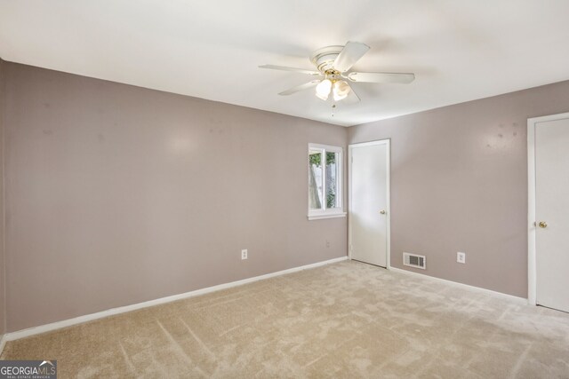 carpeted spare room featuring ceiling fan