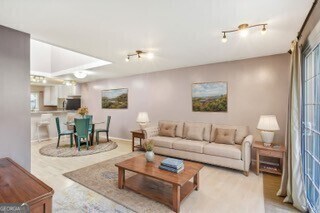 living room with track lighting, light hardwood / wood-style flooring, and plenty of natural light