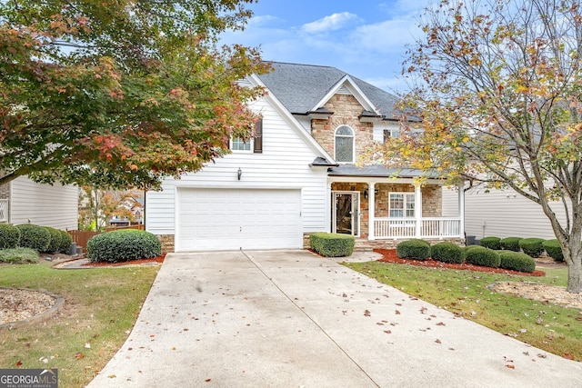 view of front of house with covered porch, a front yard, and a garage