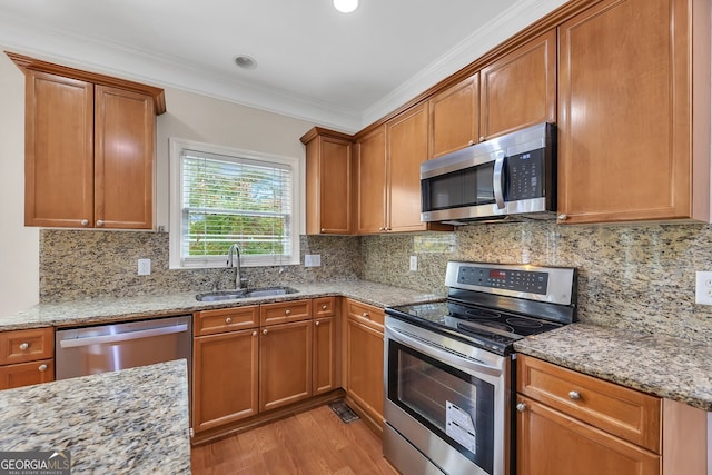 kitchen with crown molding, tasteful backsplash, stainless steel appliances, and sink