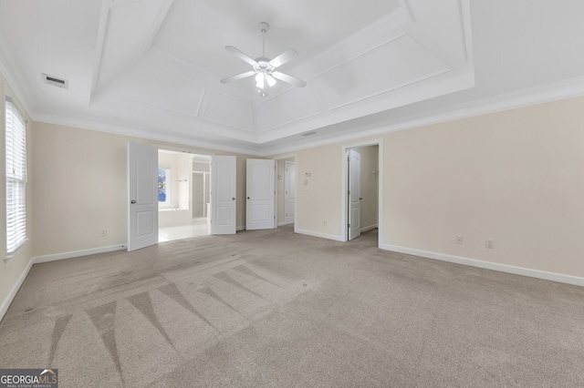 spare room with ornamental molding, ceiling fan, light colored carpet, and a raised ceiling