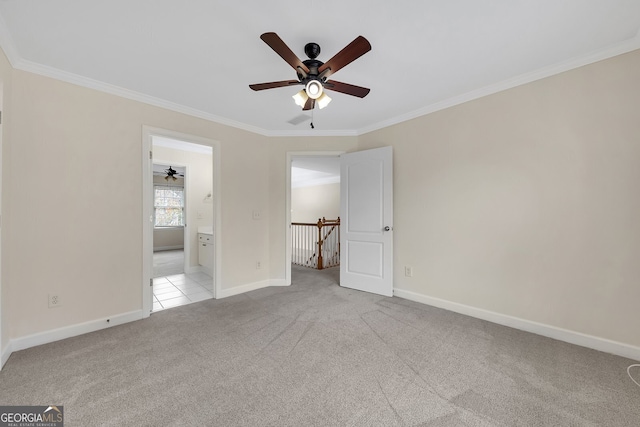 unfurnished bedroom with ensuite bathroom, ornamental molding, light colored carpet, and ceiling fan