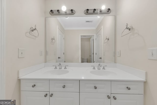 bathroom featuring vanity, crown molding, and toilet