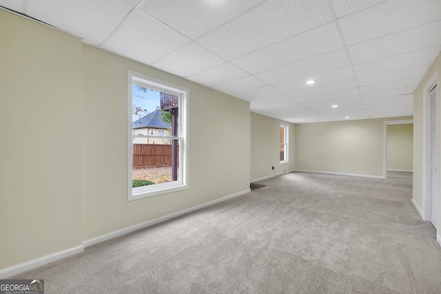 empty room featuring a drop ceiling and light carpet