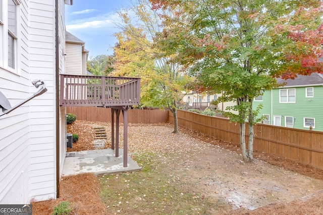 view of yard with a wooden deck and a patio