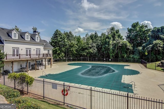 view of swimming pool featuring a patio and a wooden deck