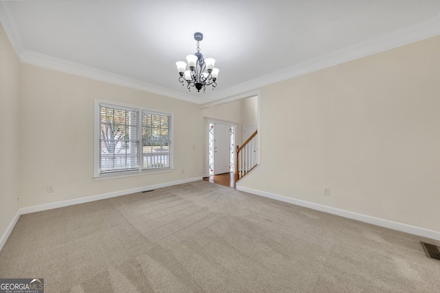 spare room featuring ornamental molding, a notable chandelier, and carpet flooring