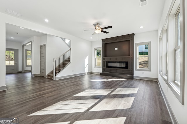 unfurnished living room featuring a wealth of natural light and dark hardwood / wood-style flooring