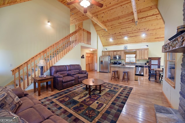 living room with beam ceiling, light wood-type flooring, high vaulted ceiling, and wood ceiling