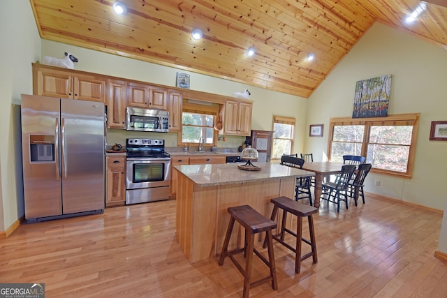 kitchen featuring light wood-type flooring, light stone counters, wood ceiling, stainless steel appliances, and high vaulted ceiling