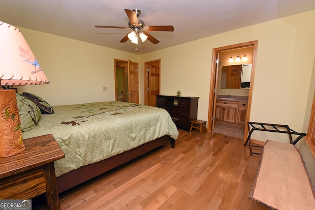 bedroom with ceiling fan, sink, connected bathroom, and light hardwood / wood-style flooring