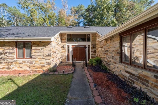 entrance to property featuring a lawn