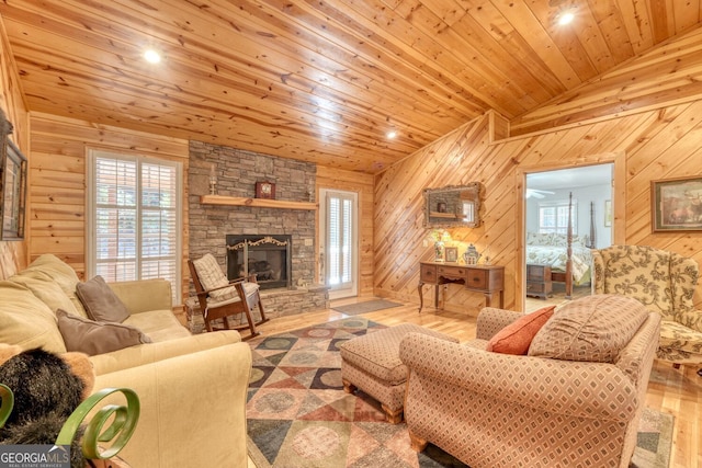 living area featuring a fireplace, wood finished floors, wood ceiling, and wooden walls