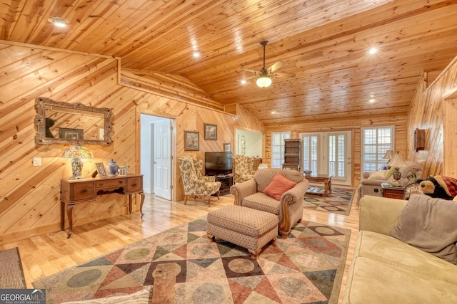 living room with lofted ceiling, light wood-type flooring, wooden ceiling, and wooden walls