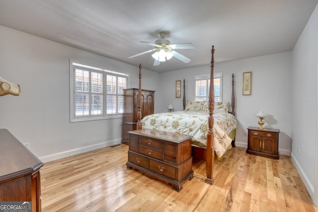 bedroom featuring baseboards, multiple windows, and light wood finished floors