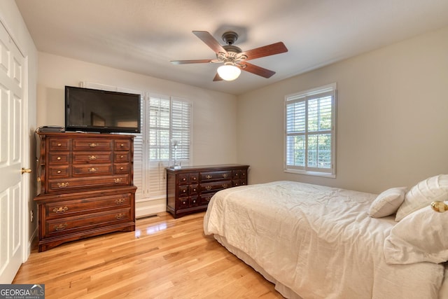 bedroom with light wood-style flooring and a ceiling fan