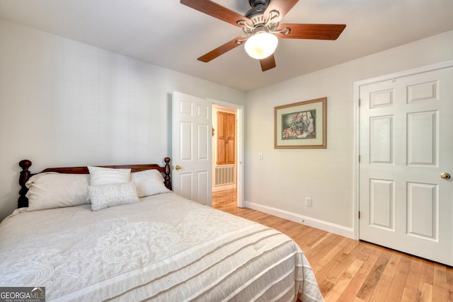 bedroom with light wood-style flooring, baseboards, and ceiling fan