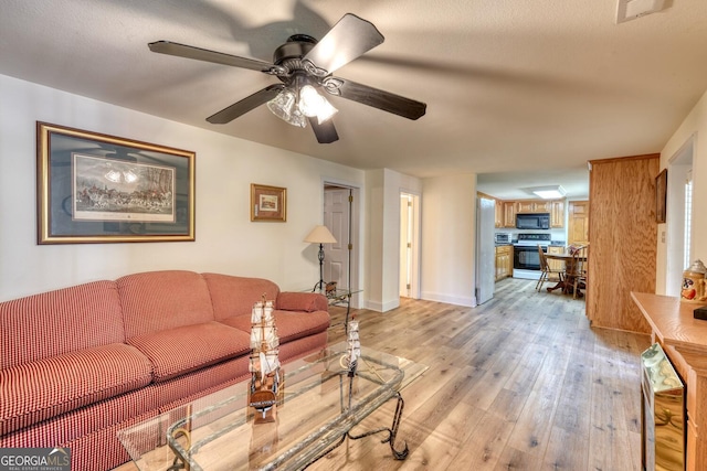 living area with beverage cooler, baseboards, visible vents, a ceiling fan, and light wood-type flooring