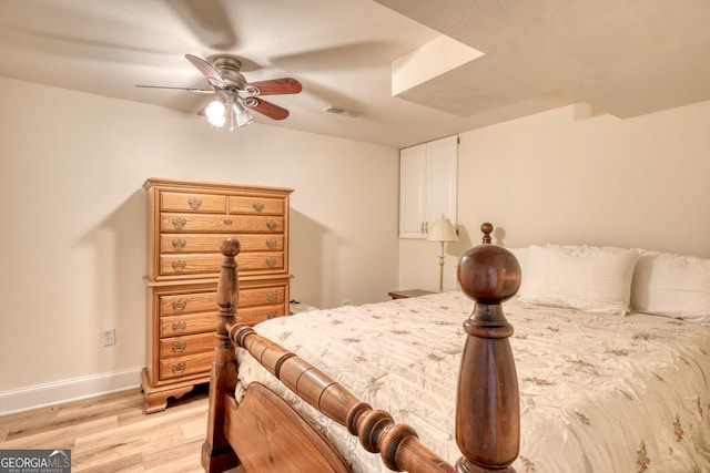 bedroom featuring light wood-style floors, baseboards, visible vents, and ceiling fan