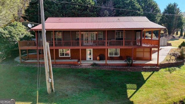 back of house with a deck, a yard, metal roof, and a patio area