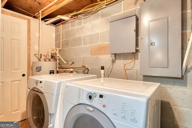 laundry room featuring water heater, laundry area, electric panel, and washer and dryer