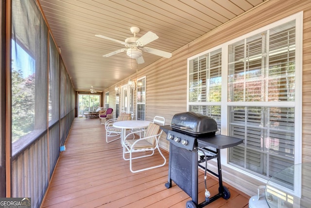 sunroom with ceiling fan and wooden ceiling