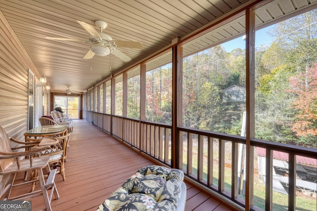 unfurnished sunroom featuring ceiling fan