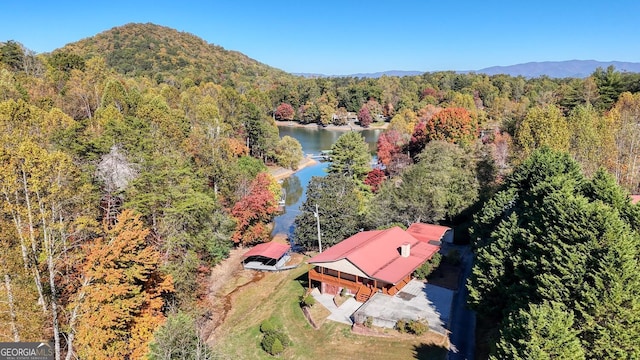 birds eye view of property with a water and mountain view and a view of trees