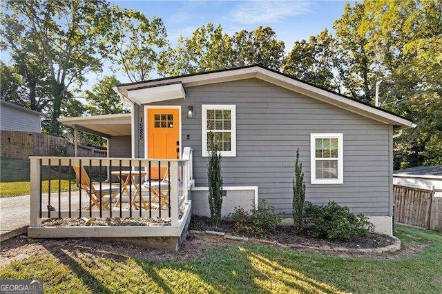 view of front facade featuring a front yard and a deck