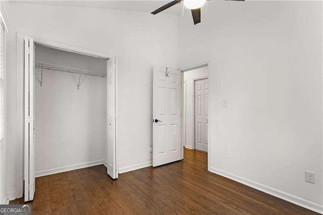 unfurnished bedroom with dark wood-type flooring, ceiling fan, and a closet