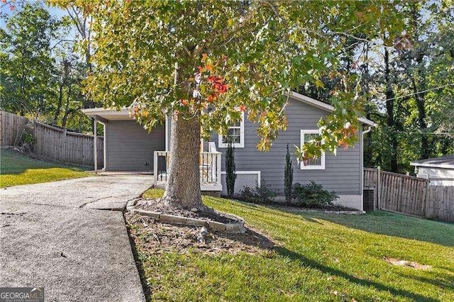 view of property hidden behind natural elements featuring a front yard