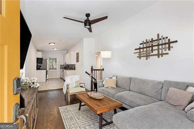 living room featuring ceiling fan and dark hardwood / wood-style flooring