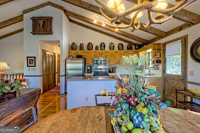 kitchen with vaulted ceiling with beams, a notable chandelier, stainless steel appliances, and dark hardwood / wood-style flooring