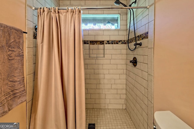 bathroom featuring toilet and curtained shower