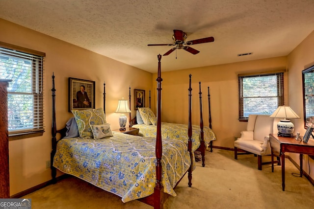 bedroom featuring carpet, a textured ceiling, and ceiling fan