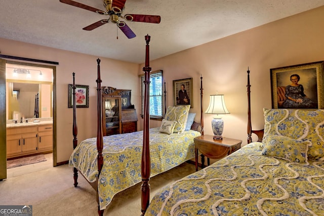 bedroom with sink, ensuite bath, a textured ceiling, ceiling fan, and light colored carpet