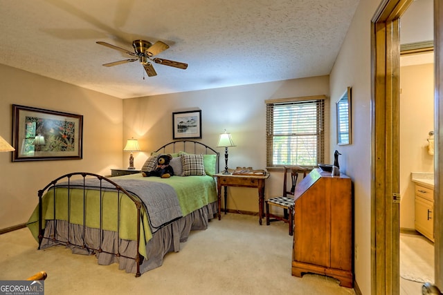 carpeted bedroom with ceiling fan, a textured ceiling, and ensuite bath