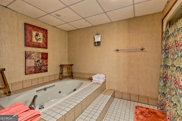 bathroom with tile patterned floors, a drop ceiling, and tiled tub