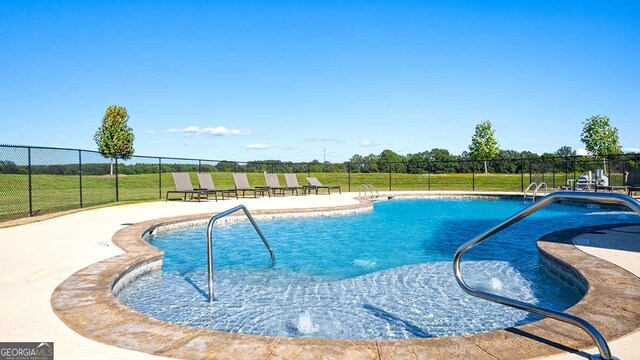 view of swimming pool with a patio area and a lawn