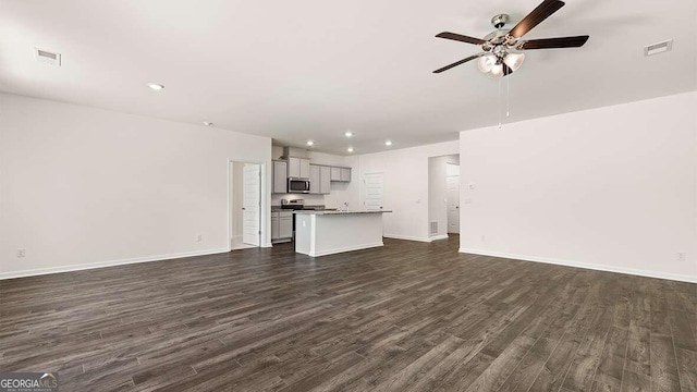 unfurnished living room with dark wood-type flooring and ceiling fan