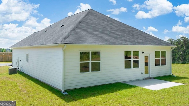 back of property with a yard and a patio