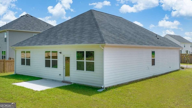 back of house with a yard and a patio