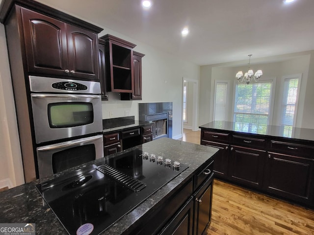 kitchen featuring open shelves, black electric stovetop, dark countertops, and double oven