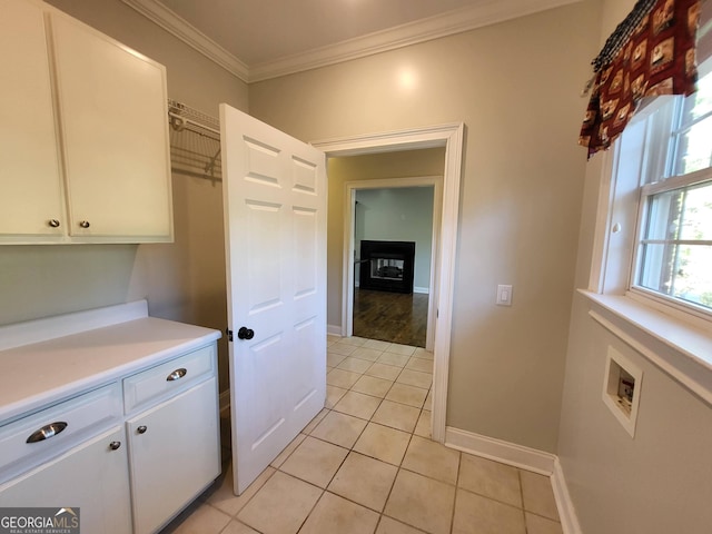 interior space with light countertops, light tile patterned flooring, white cabinetry, and crown molding