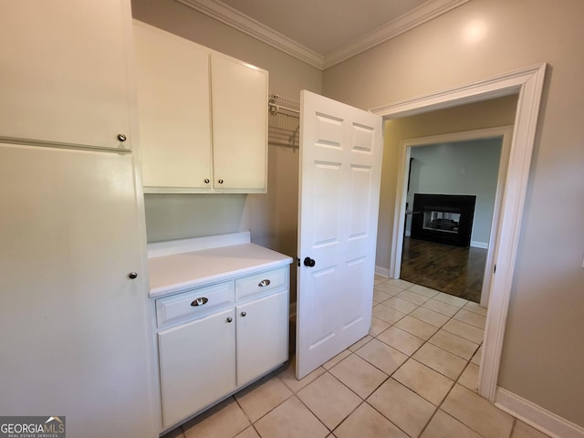 kitchen featuring light countertops, crown molding, and white cabinetry