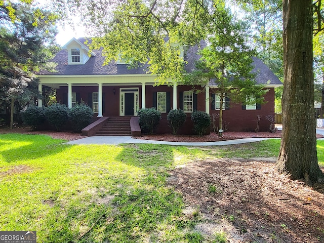 cape cod home with covered porch and a front lawn