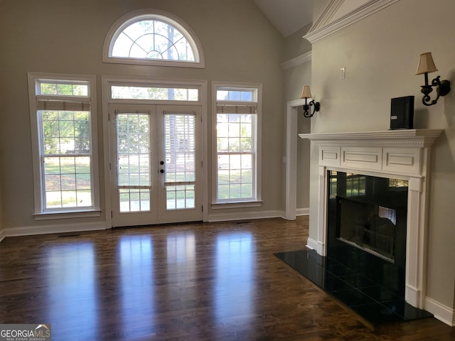 living room featuring dark wood-style flooring, french doors, a high end fireplace, high vaulted ceiling, and baseboards