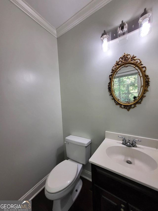 bathroom with toilet, baseboards, ornamental molding, and vanity