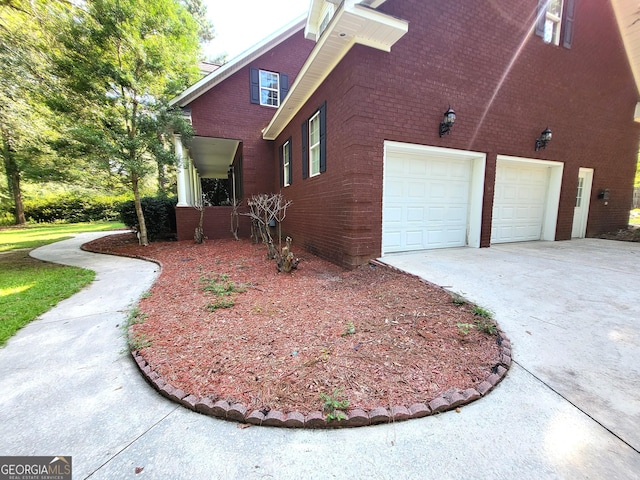 view of side of property with concrete driveway and brick siding